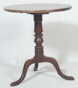 A 19th century Georgian oak wine table / tilt top table having circular top, turned column and