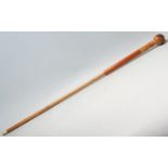 A late 20th Century gentleman's walking stick / cane having a wooden ball handle with a carving of a