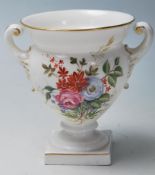 A Royal Worcester porcelain twin handled small vase urn with white ground having chintz foliate