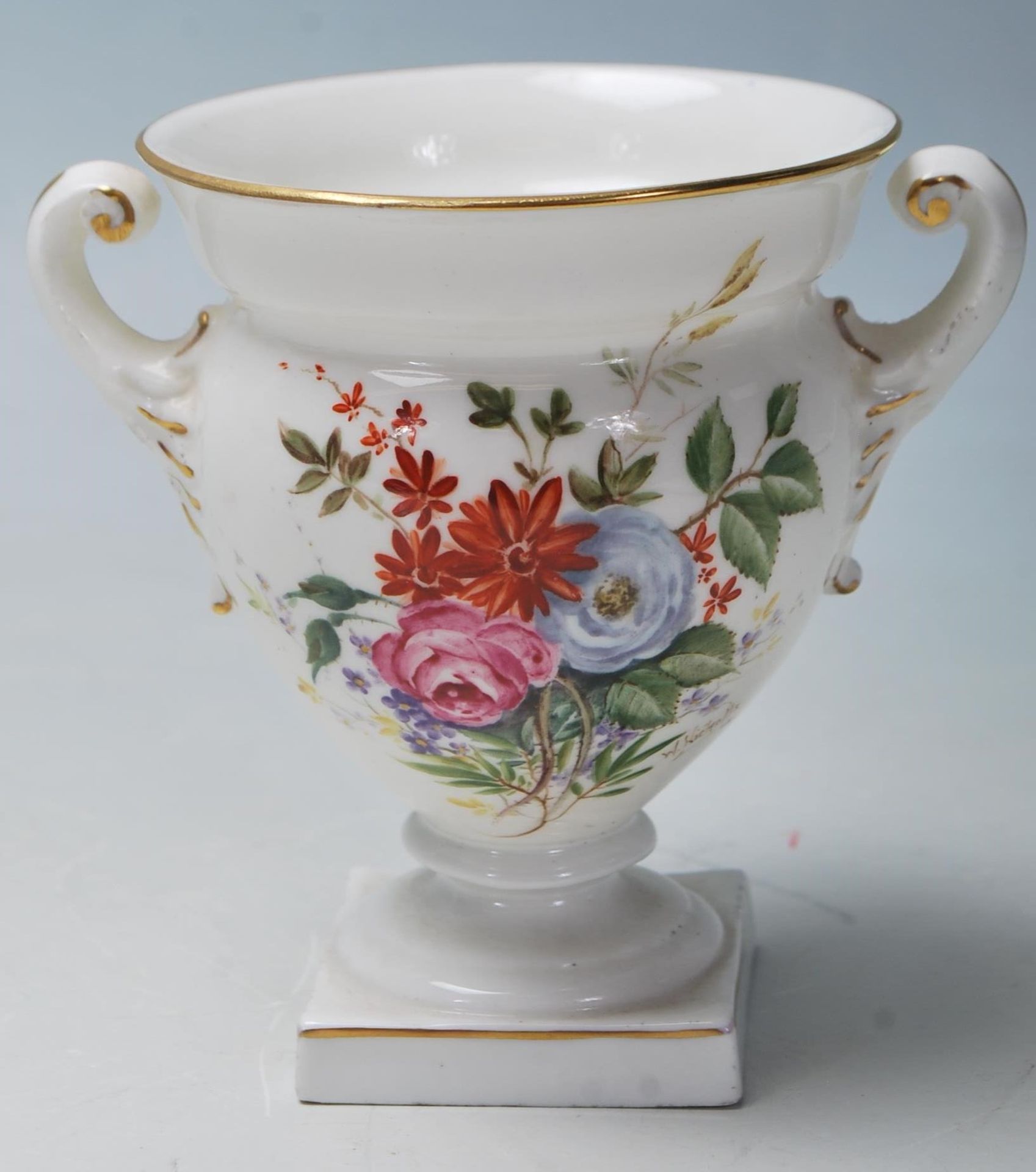 A Royal Worcester porcelain twin handled small vase urn with white ground having chintz foliate