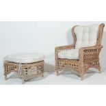 A modern 20th century wicker conservatory chair and footstool having detachable white cushions.