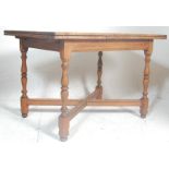 An early 20th century mahogany turned refectory draw leaf dining table. Raised on turned legs united