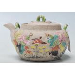 A antique Chinese believed 19th century clay teapot with coloured raised natural motif. Marked