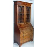 An Edwardian mahogany line inlaid bureau bookcase being raised on bracket feet with a chest of
