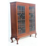 An antique style mahogany china display vitrine bookcase cabinet having a pediment top over art