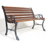 A late 20th Century Victorian style garden bench having wooden slats and shaped foliate bench ends
