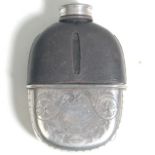 A vintage 20th Century silver white metal and glass whiskey hip flask bottle having a black