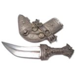 An early 20th Century Islamic white metal curved dagger / jambiya having a short curved blade with a