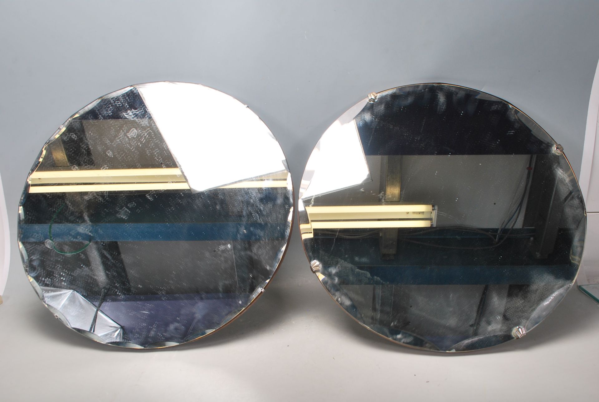 A pair of vintage retro mid 20th Century frameless mirrors of round form having wooden back panels