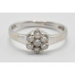 A vintage 20th Century white gold and diamond cluster ring having a flower head set with seven round