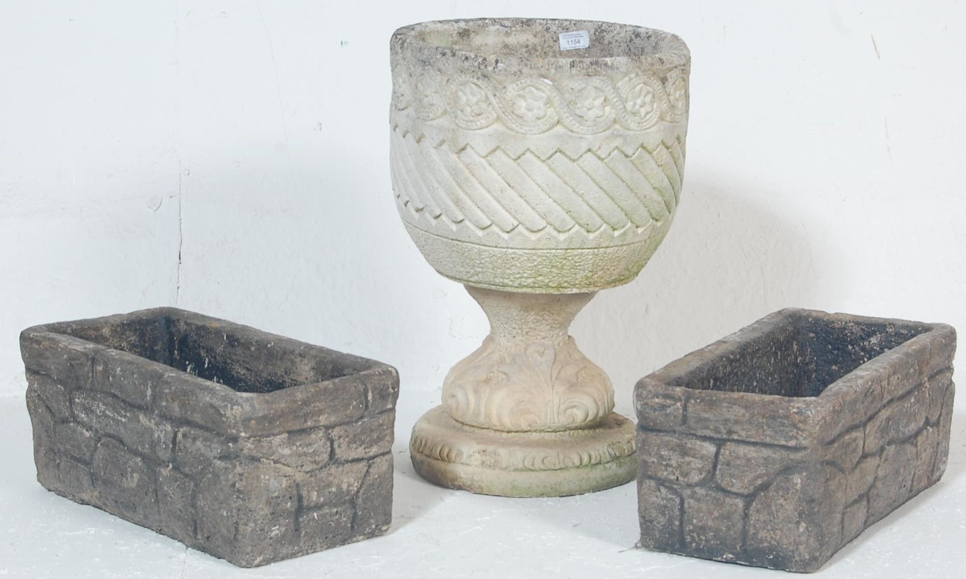 A group of three early 20th Century reconstituted stone garden planters to include a round planter