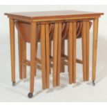 A vintage retro 20th century teak wood side table with four folding occasional / nest of four