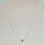 An 18ct white gold necklace pendant set with a a central ruby in a square halo set with diamond