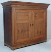 A substantial early 20th Century French Oak cupboard having a flared pediment top over a twin door