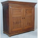 A substantial early 20th Century French Oak cupboard having a flared pediment top over a twin door