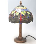 A contemporary antique style antique Tiffany lamp having a round gilt base with a leaded coloured