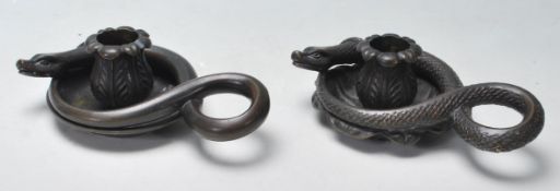 A pair of early 20th Century bronze candlesticks. The candlesticks have a central lotus flower