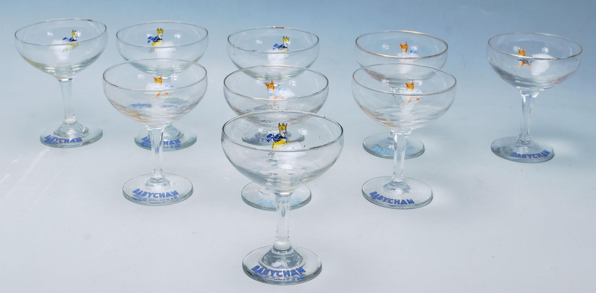A set of nine vintage retro Babycham advertising glasses having gilt rims with hexagonal stems and