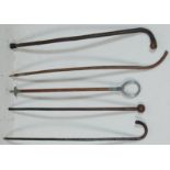 A collection of vintage wooden walking stick canes having knob handles and twist bodies together