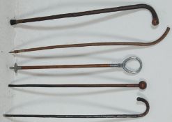 A collection of vintage wooden walking stick canes having knob handles and twist bodies together