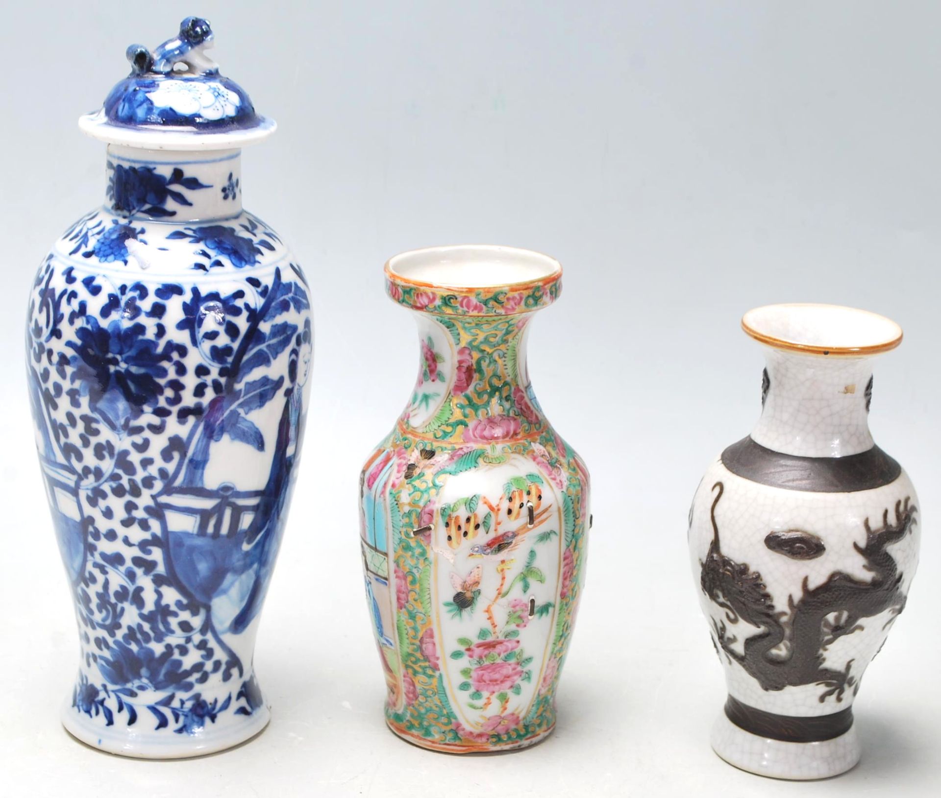 A group of three Chinese porcelain vases to include a blue and white hand painted lidded vase having