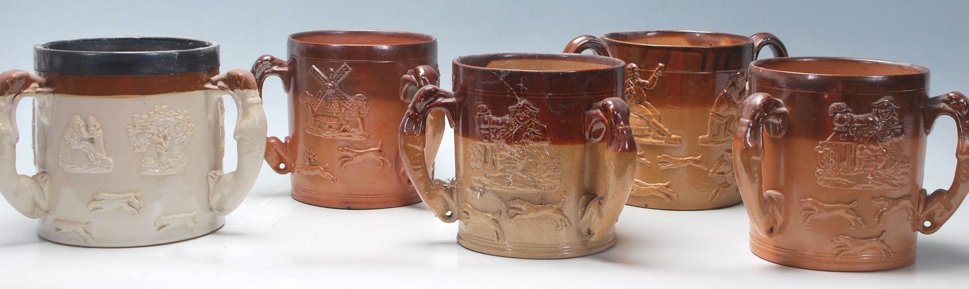 A collection of early 20th century stoneware Doulton Lambeth style havestware flagons / drinking