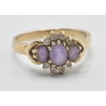 A hallmarked 9ct gold ladies ring being set with three oval cut purple stones with white accent