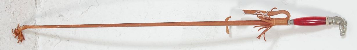 A slim late 20th Century vintage dagger / having a horses head pommel over a cranberry coloured