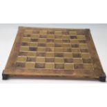 A 20th Century brass chess board raised on bracket feet with ebonised squares together complete with