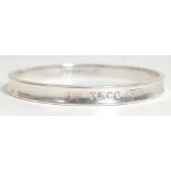 A vintage silver Tiffany bangle bracelet of typical round form with engraved T & Co, the interior