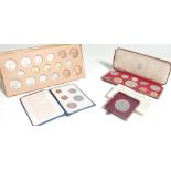 A collection of coin sets to include ER Coronation set in burgundy leather presentation case, Silver