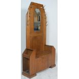 A 1930's Art Deco oak hall stand - settle bench. The hallstand with centre seat having hinged top