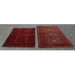 A pair of Islamic / Persian carpet rugs comprising of a red and black carpet having three