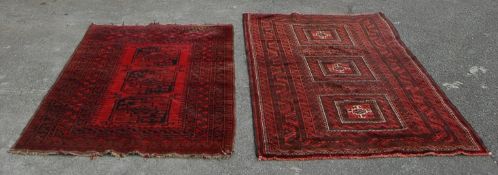 A pair of Islamic / Persian carpet rugs comprising of a red and black carpet having three