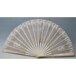 A late 19th / early 20th Century bone and lace hand fan being hand painted with butterflies and