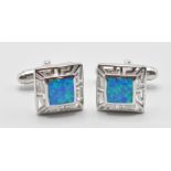 A pair of 925 silver and opal set cufflinks having pierced decoration margins in a square shape.