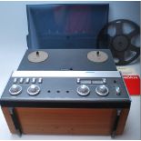 A vintage Revox A77 reel to reel stereo tape recorder having teak wood case, dark perspex dust cover