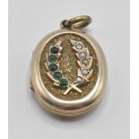 A late 19th / early 20th Century Victorian / Edwardian gilt locket having a crossed wheat sheath