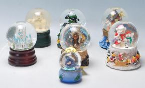 A collection of seven original vintage collectable glass snow globes to include: two angels