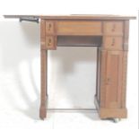 An early 20th century Edwardian sewing table machine table / desk having a drop leaf to the left and