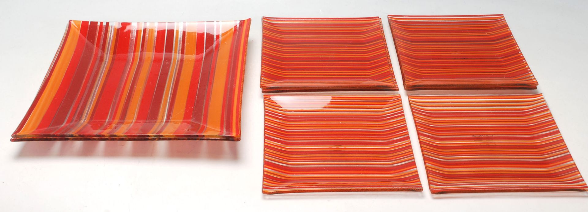 A set of 1970's studio art glass square dishes each of multi coloured lined form in the manner of