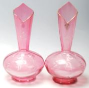 A pair of 19th Century Victorian cranberry glass stem vases of bulbous form having painted white