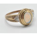 A 9ct gold 20th Century ring set with an oval cabochon bezel set in a stepped mount flanked with two