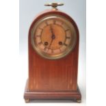 An early 20th Century Edwardian dome top mantel clock having an inlaid oak body with a brass and