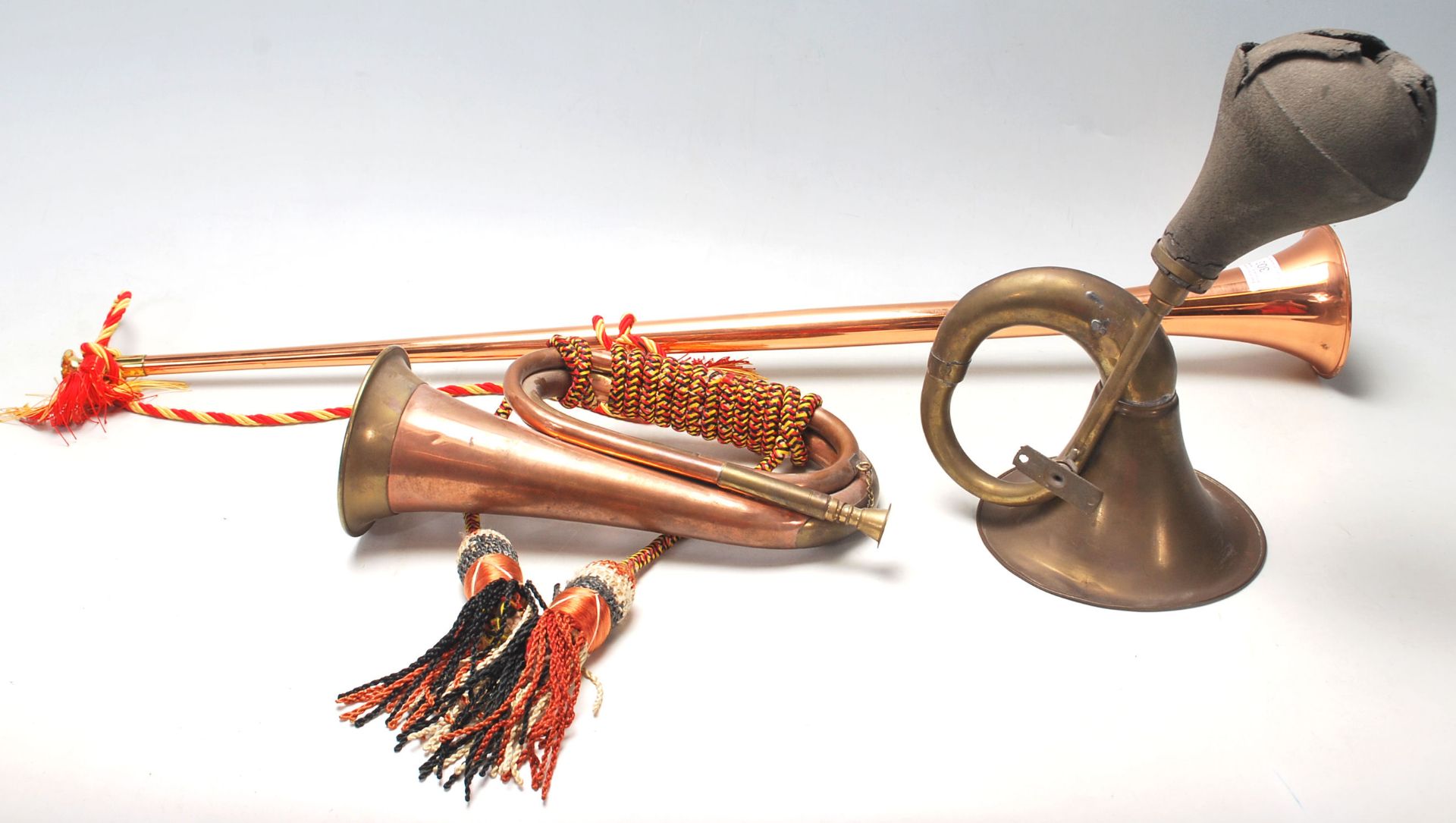 A collection of early 20th Century brass horns to include a pair of hunting horns with tassels and a
