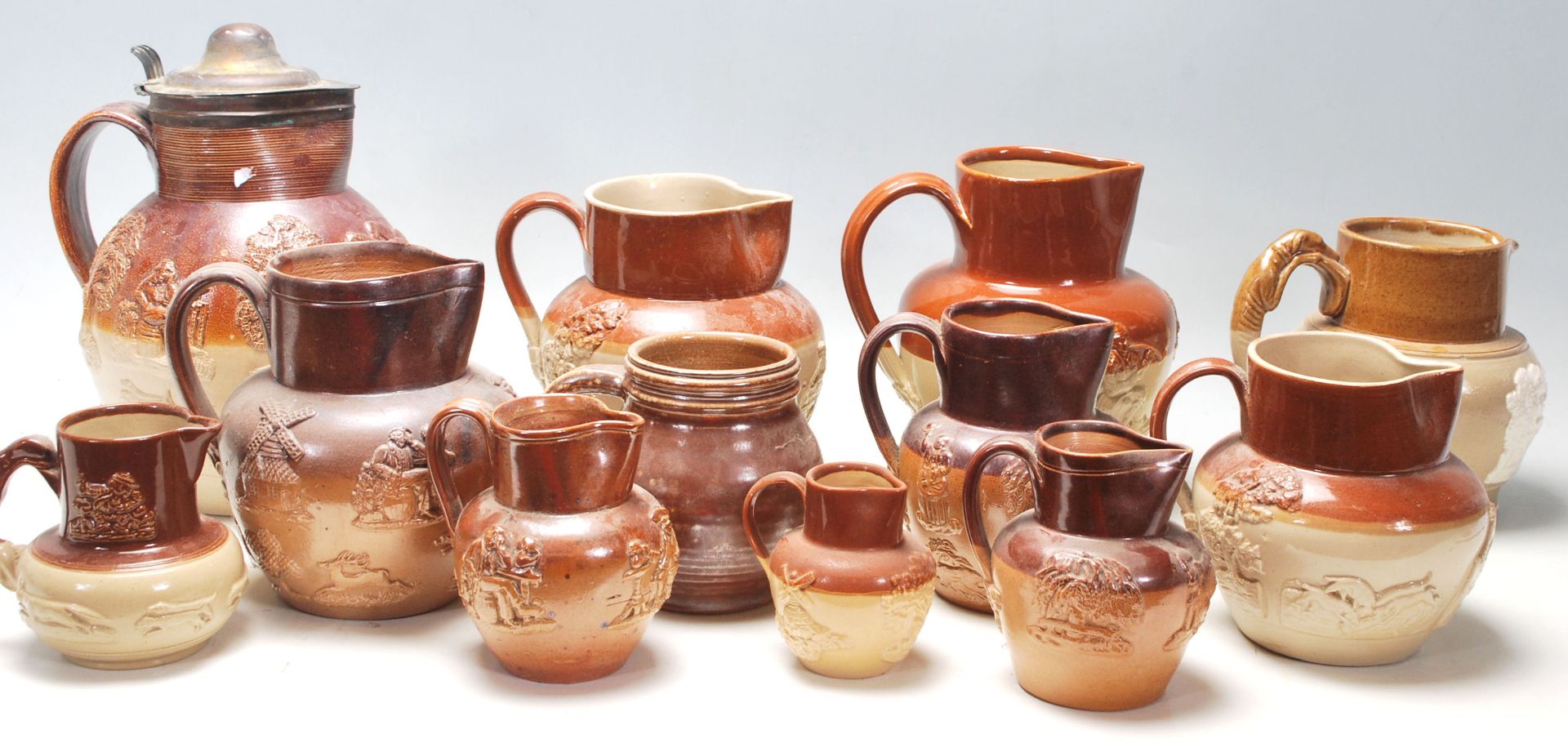 A collection of Lambert Doulton style Harvest ware /  stoneware flagons / drinking vessels / jugs