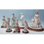 Auro Belcari - A collection of 7 china figurines by Belcari to include a boy collecting fruit, a