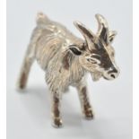 A contemporary sterling silver miniature figurine of a goat. Marked Sterling. Measures: 2cm long,