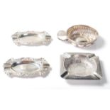 A group of four silver items to include a pair of continental silver ashtrays of oval form having