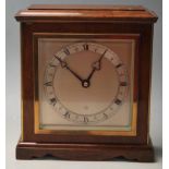 An mid century 1960s Oak mantle clock having a pediment stepped top over a large brass and brushed